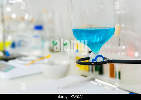 Close up of a part of glass flask with blue liquid. Healthcare and biotechnology concept Stock Photo