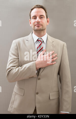 Businessman In Formalwear With Hands On Chest Stock Photo