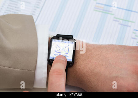 Close-up Businessperson Hand With Smartwatch Showing Unread Message Icon Stock Photo