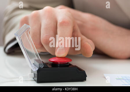 Close-up Of Businessperson Hand Pressing Red Emergency Button Stock Photo