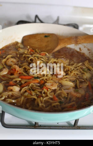 Close up of shrimp lo mein frying on a stove Stock Photo