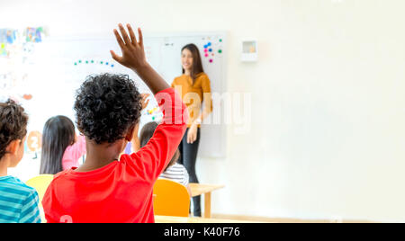 African American ethnicity kid hand up for answer question of teacher in classroom,Kindergarten preschool education concept,Mock up banner space for a Stock Photo