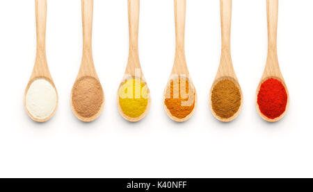 Wooden Spoon filled with colorful spices on white background Stock Photo