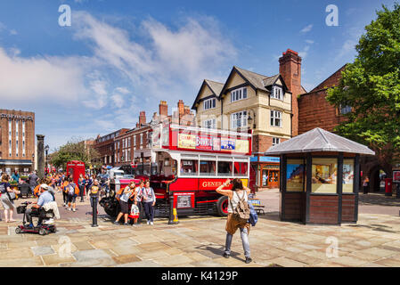 18 July 2017: Chester, Cheshire, England, UK - Group of young women having a photo taken beside a vintage tour bus in Northgate Street. Stock Photo