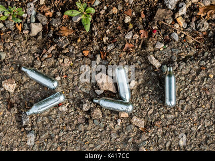 Nitrous Oxide whippits on urban street Stock Photo