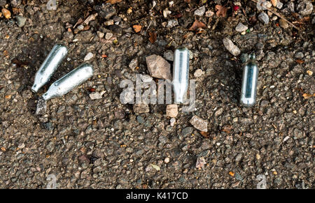 Nitrous Oxide whippits on urban street Stock Photo