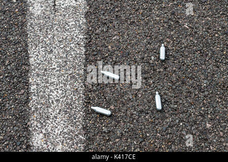 Nitrous Oxide whippits on urban street Stock Photo