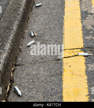 Nitrous Oxide whippits on urban street Stock Photo