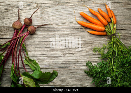Fresh vegetables of carrots and red beets on wooden background Stock Photo