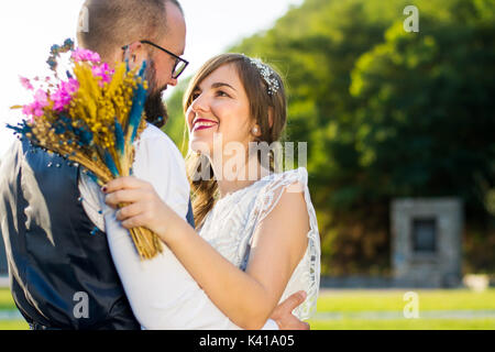 Bride and groom in romantic hug at sunset time Stock Photo