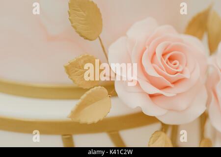 Pastel pink and gold icing flower wedding cake topper Stock Photo