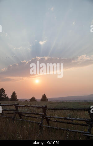 Beautiful sunset with sunrays behind the clouds Stock Photo