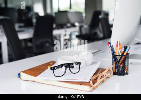 Office desk with computer, notebook and eyeglasses. Stock Photo