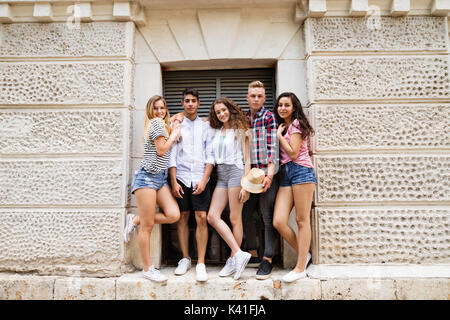Attractive teenage students posing in front of university. Stock Photo