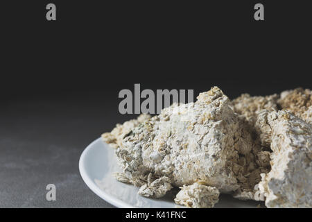 Mold growing rapidly on moldy bread in white spores. Close up stack of moldy bread on white plate. Stock Photo