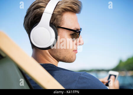 A photo of young, relaxed man listening to the music and dreaming. Stock Photo