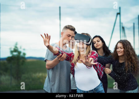 Attractive teenagers on playground. Girl with VR glasses. Stock Photo