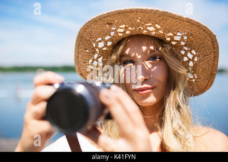 A photo of young, beautiful woman taking a photo. She seems to be glad. Stock Photo