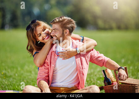 A photo of young, happy couple head over heels in love. They're cuddling and smiling. Stock Photo