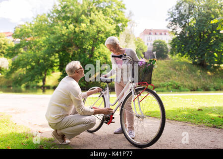 happy senior couple with bicycle at summer park Stock Photo
