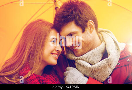 smiling couple with umbrella in autumn park Stock Photo