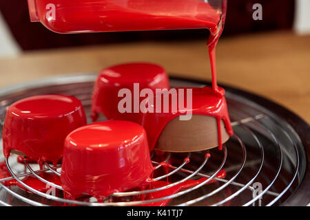 jug pouring glaze to cakes at pastry shop Stock Photo