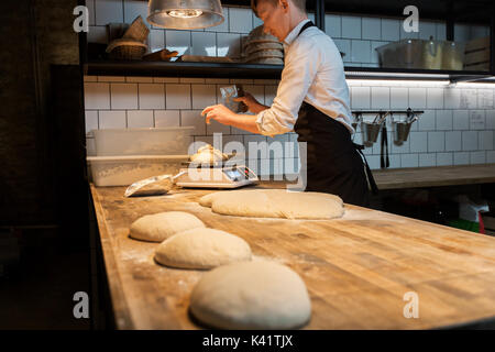 baker weighing bread dough on scale at bakery Stock Photo - Alamy