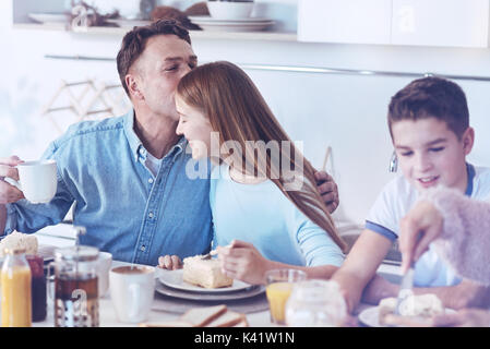Loving father kissing teenage daughter on forehead Stock Photo