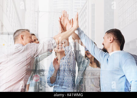 Cheerful office workers giving high five each other Stock Photo