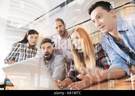 Surprised young colleagues using laptop in the office Stock Photo