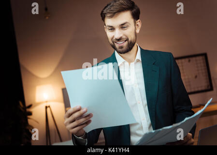 Positive delighted brunette reading documents Stock Photo