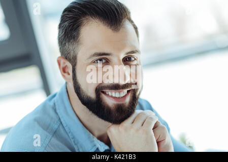 Cheerful man resting his chin on hands and smiling Stock Photo