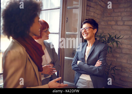 Group of females at work talking together in office Stock Photo