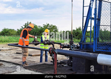 Two petroleum engineers at work on an European oil well Stock Photo