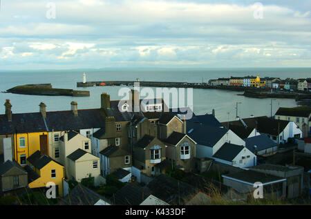 A view of the harbour and lighthouse at the County Down village of  Donaghadee in Northern Ireland taken across the rooftops from the Moat Stock Photo