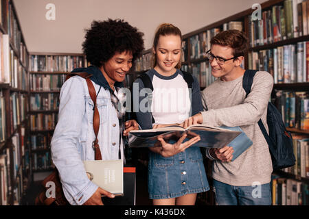 Group of college students discussing in the library. university students studying together in library. Stock Photo