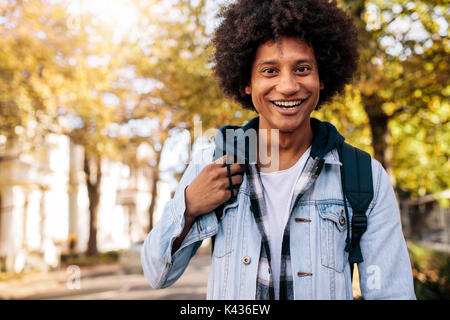 Young man with backpack going to school college. university student standing on the road with smiling. Stock Photo