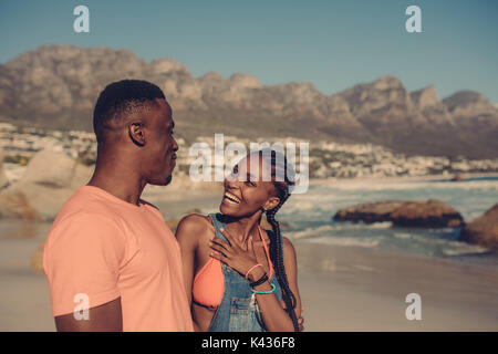 Young couple having fun at the beach. Happy african man and woman on a beach vacation. Stock Photo