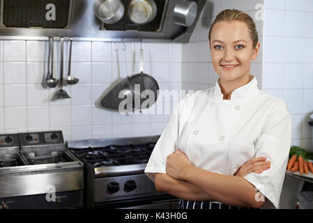 Portrait Of Female Chef Standing In Kitchen Stock Photo