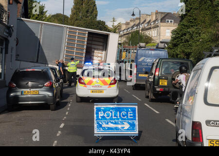 BATH, UK - 01 SEP 2017 Lorry stuck on steep hill with driver and police and sign. HGV unable to move after attempting a sharp turn off London Road Stock Photo