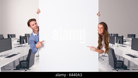 Digital composite of Business people holding blank card in office Stock Photo