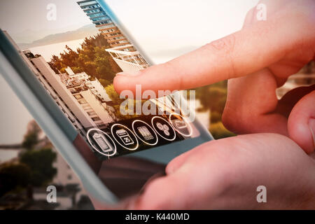 Hands using tablet on white background against white buildings by sea Stock Photo