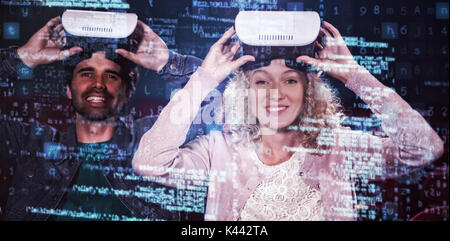 Image of data against couple using virtual reality headset Stock Photo