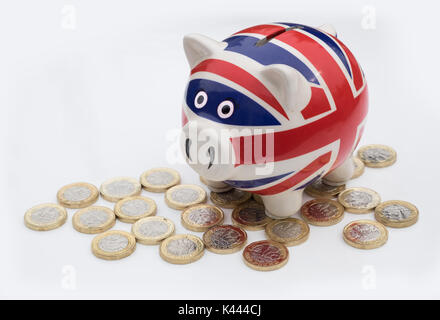Piggy bank style money box with UK sterling money coins Stock Photo