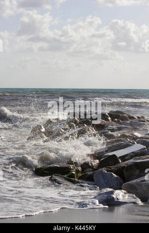 MARINA DI MASSA, ITALY - AUGUST 17 2015: Waves crashing into rocks in Marina di Massa, Italy Stock Photo