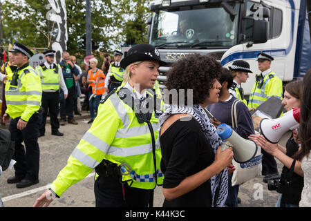 London, UK. 4th Sep, 2017. Police officers usher campaigners against the arms trade and the supply of arms to Israel out of the road after they blocked the entry of a truck carrying military equipment into the ExCel Centre for the DSEI arms fair. Credit: Mark Kerrison/Alamy Live News