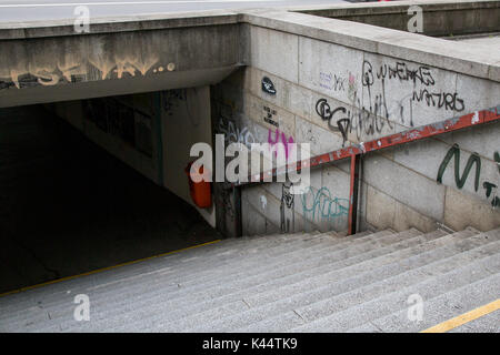 The steps leading to a pedestrian underpass below a road in Linz, Austria are covered in graffiti. Stock Photo