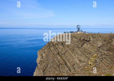 The sea cliffs at the North Cape in Nordkapp north Norway. With the Globe Statue silhouetted over the horizon. Stock Photo