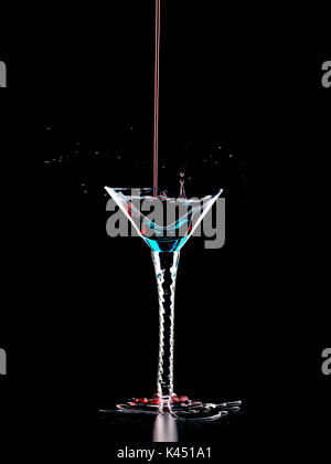 Crying over spilt wine.Wine overflowing out of broken turquoise glass. It was my favourite, beautiful glass. Stock Photo