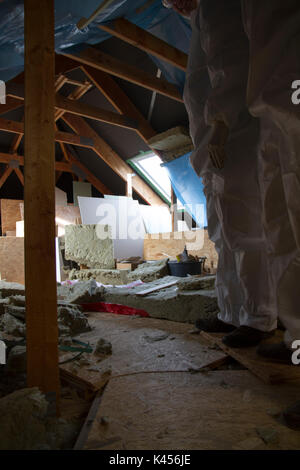 house attic insulation - construction worker installing rock wool in ...
